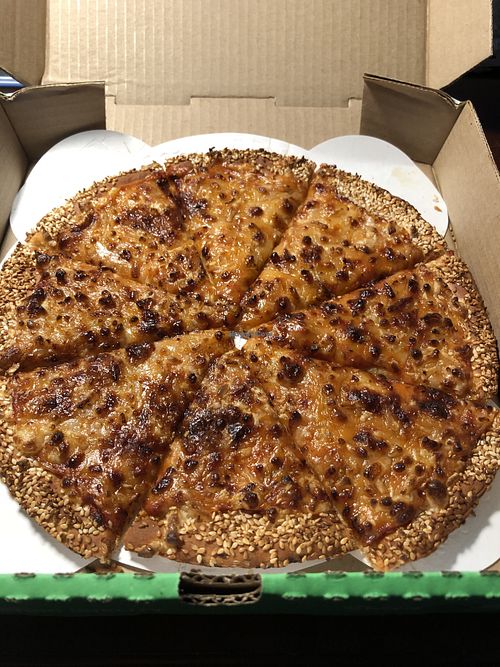 Perfectly done vegan cheese pizza with a cauliflower crust and sesame seeds   at Red Swan Pizza in Regina