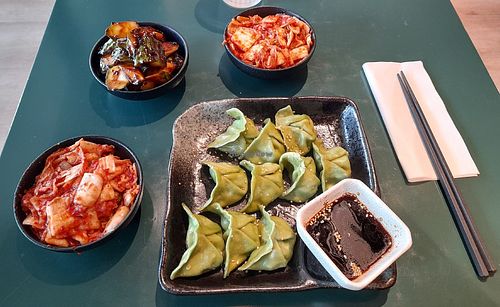 Dumplings filled with tofu, spinach, scallion, ginger and zucchini. Side dishes: kimchi, radish kimchi and cucumber chili. at Noodle Story - Iso Omena in Espoo