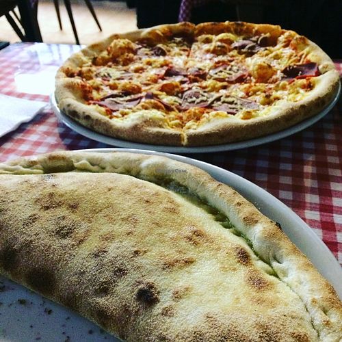 Vegan salami cheese pizza and vegan calzone at Zeus Pizza in Berlin
