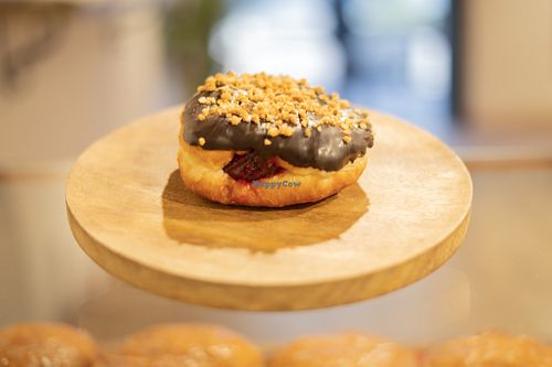 Berlina rellena de mermelada de frambuesa bañada en chocolate negro y topping de crocanti de almendra. at Cobs & Tops - Terrassa in Terrassa