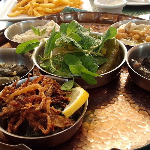 Cold mezza: hummus, baba ganoush, stuffed grape leaves, stuffed chard, dandelion greens with fried onions, french fries, toom, pita bread at Hallab 1881 قصر الحلو in Tripoli