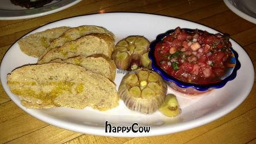 Whole Roasted Garlic with tomato basil relish and crostinis (vegan) at Om Cafe - Traverse City in Traverse City
