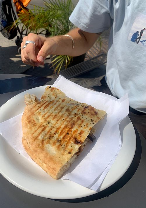 Tal enjoying traditional Sicilian pizzolo at Vegan Food Tour Ortigia in Siracusa