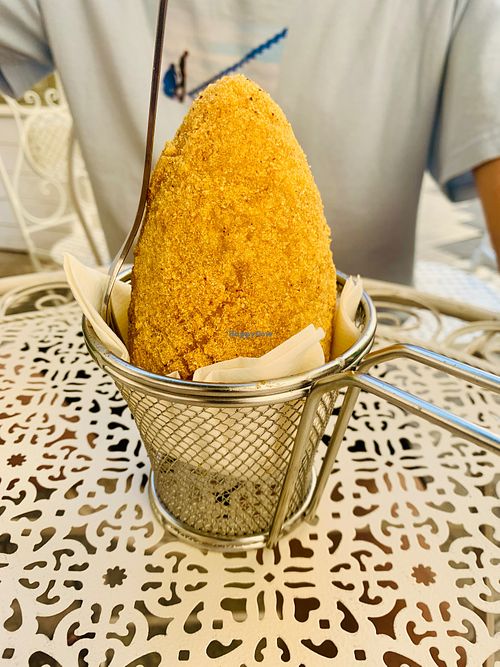 Tal trying the vegan Sicilian arancino at Vegan Food Tour Ortigia in Siracusa