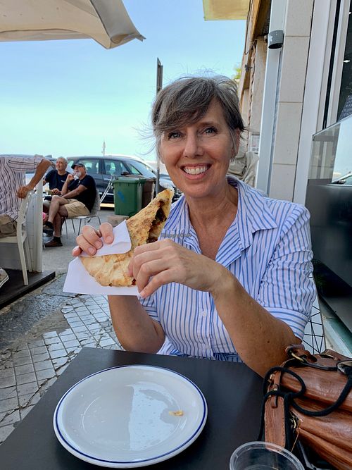 Tonia, the tour guide, enjoying her vegan pizzolo at Vegan Food Tour Ortigia in Siracusa