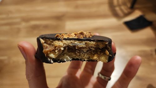 Chocolate covered shortbread with dulce de leche filling and hazelnut topping at Vegansté in Providencia