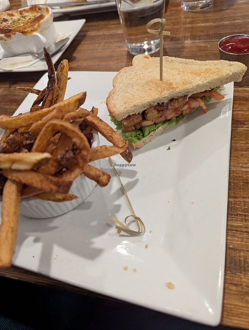 Picture of half of a tempeh BLT and some fries that are orange. at Root'd Cafe in Cottonwood Heights