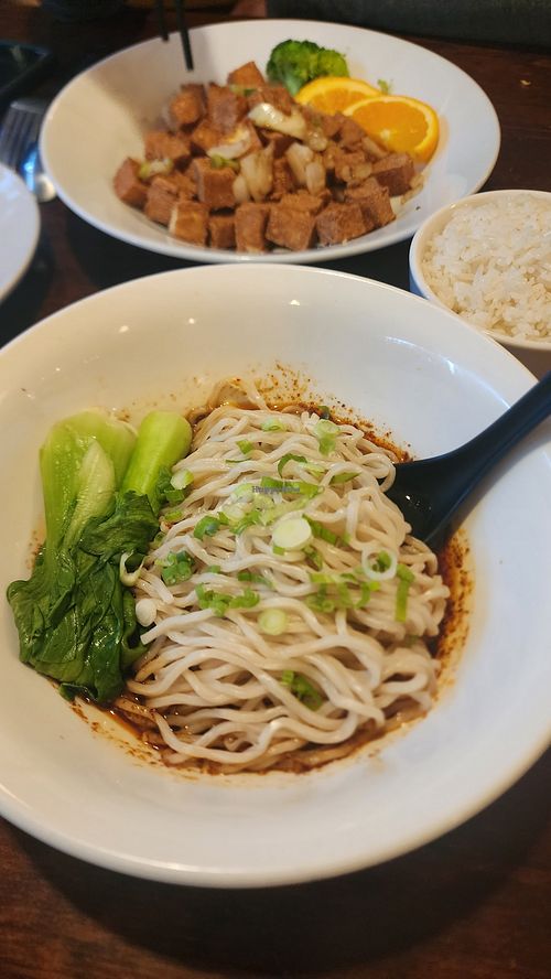 CHILI SAUCE NOODLES: 
Flour noodles served in the house chili oil vinaigrette and topped with scallion and bok choy. Crispy Fried Tofu in background at Kitchen Master in Frisco