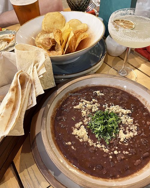 Delicious and hearty vegan red bean soup topped with walnuts and cilantro. A little further away—homemade potato chips and hummus. at Machar 44 in Yerevan