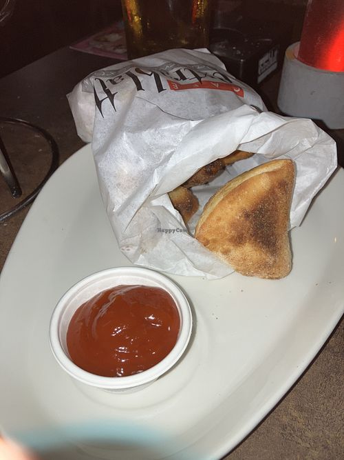 Pizzabrötchen with one piece already being eaten   at Cafe Extrablatt in Sylt