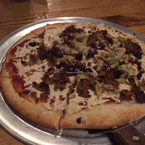 gluten free, vegan cheese, vegan Italian sausage, pine nuts, & artichokes pizza at The Mitten Brewing Co in Grand Rapids