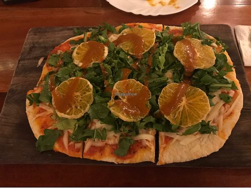 Vegan pizza with tangerines at La Hoja Verde in Tulum