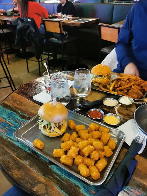 Vegan fried chicken burger and tater tots (front) at Birdhouse in Dollard-des-ormeaux