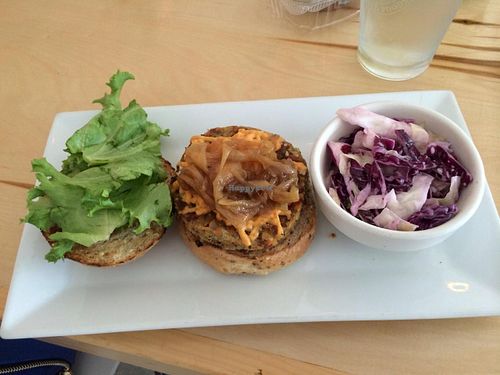 Smokehouse burger: Brown rice, quinoa, chickpea, roasted vegetables, parsley, sunflower seeds, garlic, spice mix, melted 'cheese', caramelized onions, bbq sauce all on a burger bun & served with a side at Green Bar and Kitchen in Fort Lauderdale