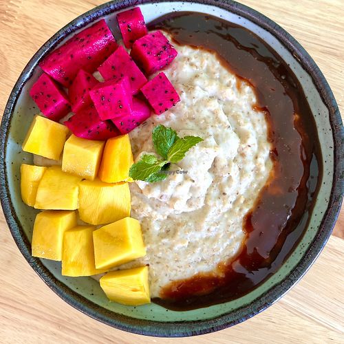Oatmeal: Creamy oatmeal made with coconut milk. Served with mango and dragonfruit. at Mettā Guesthouse Kampot in Kampot