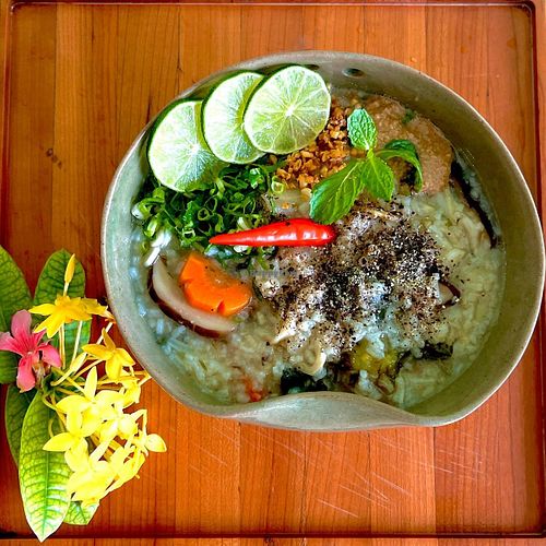 Congee / Rice Porridge: Cambodian breakfast classic. Rice porridge with mushrooms, radish, carrots, onions, garlic and sprouts. Served with a special fermented soybean sauce, chili at Mettā Guesthouse Kampot in Kampot