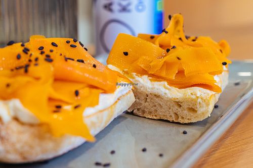 Crispy French baguette with creamy cream cheeze, hand-cut marinated carrot lox with smoky nori flavors & black seeds - plant-based salmon perfection! 🐟✨ at Veganaria in Ponta Do Sol