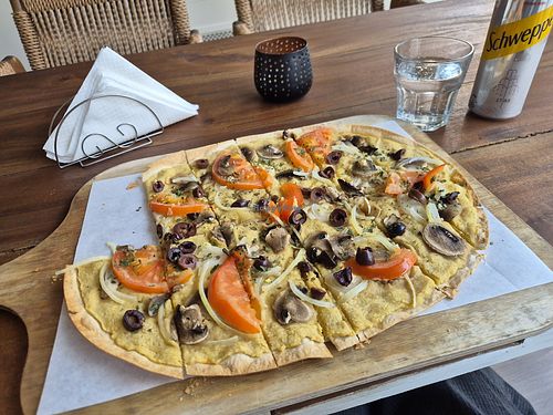Vegan Flammkuchen with hummus, olives, tomatoes and Champignons at Lisa's Flammhouse in Larnaca