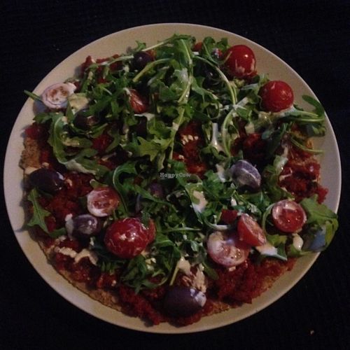 Raw vegan pizza with rocket, black olives and cashew dressing at Secret of Raw in Prague