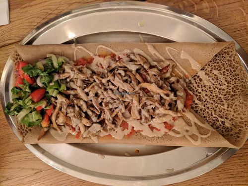 Ingoodie tibs - injera bread covered with a tomato sauce and mushrooms at Tenat in Tel Aviv