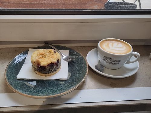 Flat white with oat milk and vegan cherry poppy cake at Man Versus Machine Coffee Roasters  in Munich
