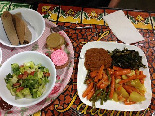 Main plate has: Gomen dish, Yatkilt dish, Fasolia dish, & a Greenbean dish
 Side plate has: Strawberry cupcake (gf), Timatam salad, & gf injera at Azla Vegan in Los Angeles