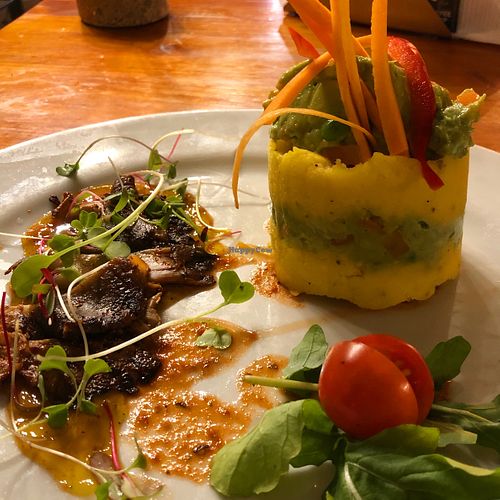 The Causa - traditional Peruvian cold potato pie with avocado mayo, served with mushrooms flambéed in pisco and Peruvian chilli sauce, all on a passion fruit base. at Green Point in Cusco