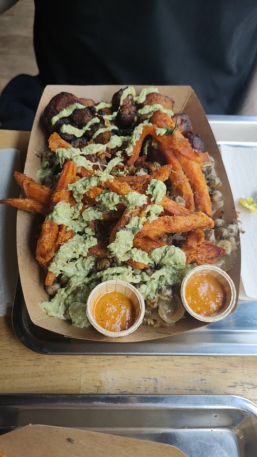 XL portion: jollof rice with chickpeas, Yassa sauce, plantains and Cajun sweet potato fries, plus extra green sauce and chili sauce at Osè African Cuisine  in Paris