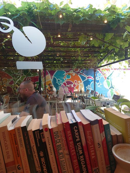 Inside with plenty of books 📚 and seating outside at Zrno Bio Bistro in Zagreb