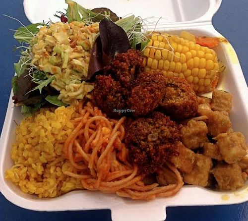 Large-sized lunch: Caribbean seasoned brown rice, spaghetti with vegan cheese, lentil fritters, tofu in a peanut sauce, corn on the cob, living sprouts salad at Natural Vybz Rootz Cafe in St John