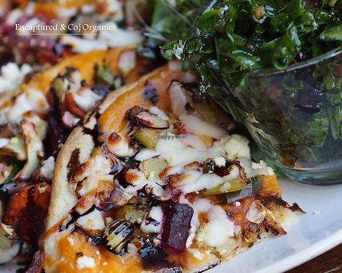 Roasted Veggie Pizza is deliciously seasoned with Autumn Spices, Organic Veggies on a traditional crust with a sweet potato and butternut squash puree base, lite sprinkles of feta and mozzarella cheeses finished with a balsamic drizzle!  at Sprouts Cafe in Gastonia