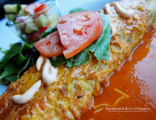 Veggie Brown Rice Enchilada! Seasoned, Organic grilled Veggies with Long Grain Brown Rice in a Spinach Tortilla with Chipotle Aioli and a mixed cheeses baked and topped with homemade enchilada sauce!   at Sprouts Cafe in Gastonia
