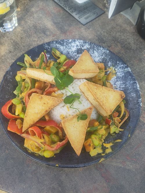 Deze vegan groente curry met tofu was echt heerlijk van smaak.  Bovendien zaten er edamame boontjes in wat het met de rijst en tofu tot een voedzame maaltijd maakte. at Het Strand in Katwijk Aan Zee