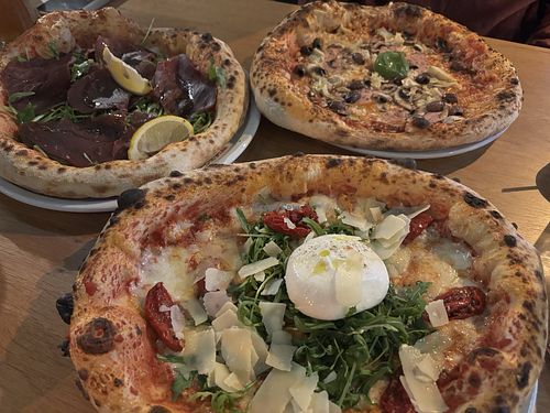 Top right pizza is topped vegan with vegan cheese, olives mushrooms, artichokes and vegan ham. Bottom one is topped with various cheeses. Top left is topped with beef ham. at Lausbub Pizza Napoletana - Nürnberg Ost in Nuremberg