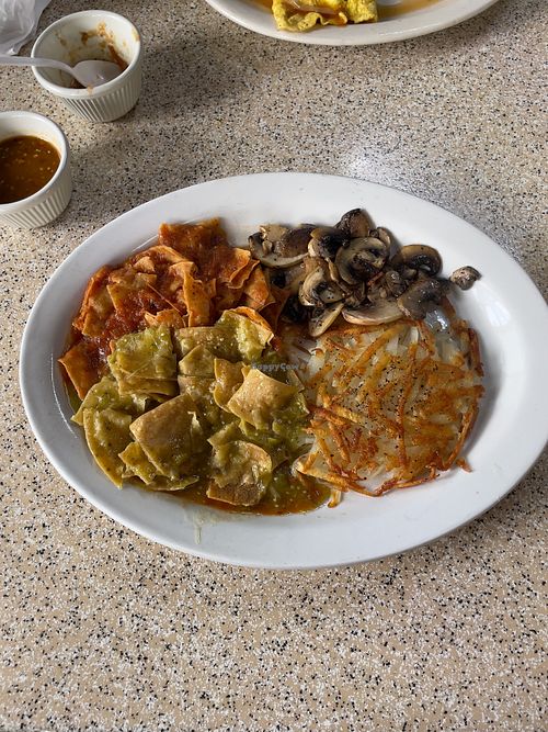 Chilaquiles with hash browns and sautéed mushrooms. at El Correcaminos in Villa De Juarez