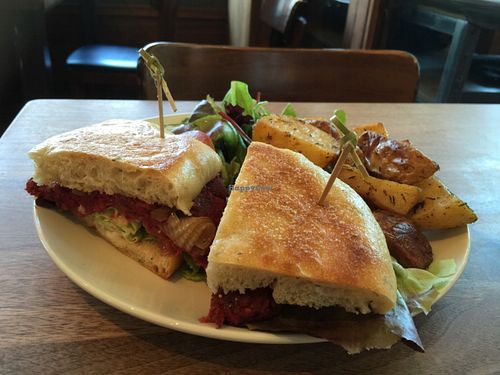 Plant burger with focaccia, lentil, mushrooms, cashew. Served with country potatoes and salad  at The Plant Cafe Organic Cafe in Burlingame