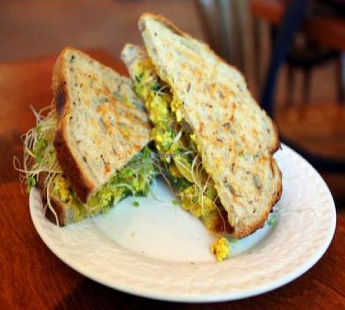 tofu scramble sandwich: turmeric seasoned tofu with onions, mushrooms and spinach, grilled on rye bread, with sprouts. at Chaco Canyon Organic Cafe - University District in Seattle