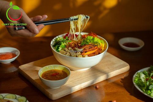 Bún trộn (vermicelli noodle salad): noodles, green herbs, cucumber, pickles, grilled seitan, vegan charsiu, toasted nuts,deepfried onion, special sauce at Chay Yêu Thương in Nha Trang