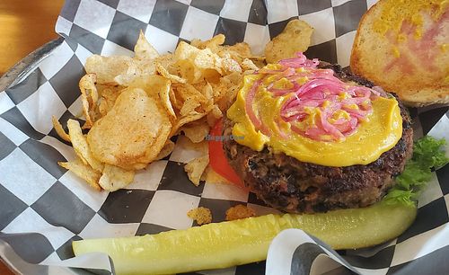 Honemade black bean burger w/lettuce, tomato, cashew cheese sauce, & pickled red onions. Comes with cajun chips. at Burn 'Em Brewing in Michigan City