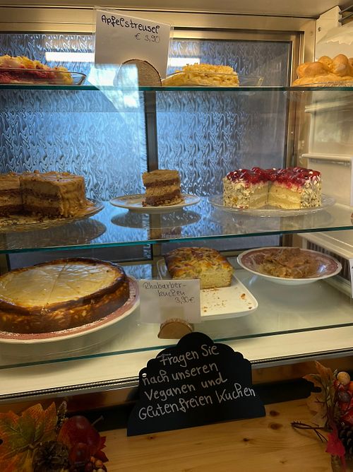 3 vegan cake options and a sign stating „Please ask for our vegan and gluten free cake options“  at Pfeiffer Alm in Garmisch-partenkirchen
