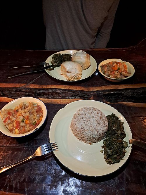 Vegan chicken stew, accompanied by sorghum, spinach, dumplings, and bean leaves. at Planet Culture Café in Maun