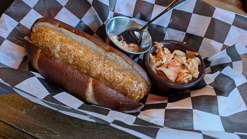 Beyond Brat comes on a pretzel bun with stone ground mustard and kraut at 64 Taphouse & Bar in Hood River