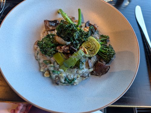 Field and porcini mushroom risotto, charred broccolini, Szechuan roasted walnuts and crispy kale finished with white truffle oil and vegan cheese at Panorama Room in Mt Cook