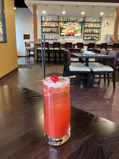 Virgin Strawberry Mojito with the full bar in the background. at Saffron Indian Grill & Bar in Eagan