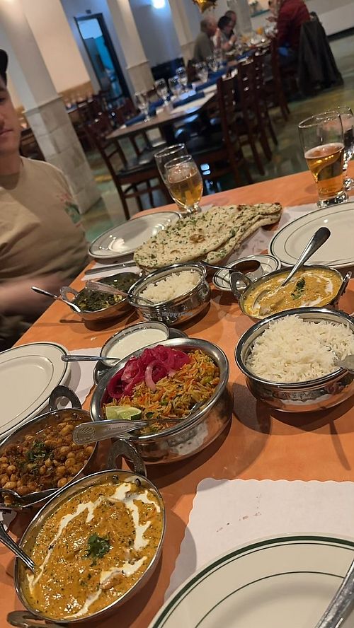 Chana masala, vegetable biryani (Raita on the side for non-vegan friends), tofu paneer. The yellow curry on the right contains chicken (not ours) is not vegan.   at Bombay Palace in Murray