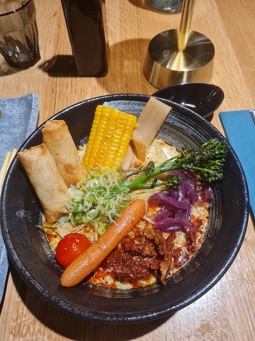 Vegan ramen: 2 veg spring rolls, corn, broccolini, baby carrot, sundried tomatoes, cherry tomato, *pickled onions, *slices of bamboo shoot (*not sure) in creamy coconut broth. at HAV Sushi & Ramen in Tromsoe