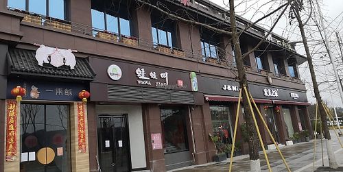 The sign has changed and should now be the one on the left side of the picture. The restaurant is on the upper level, occupying the entire top floor at the corner above the clothin at Hongmei Zhi Jiayi Liangfan Vegetarian Restaurant in Chengdu