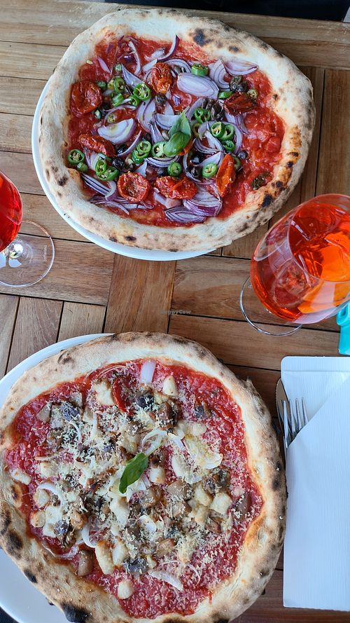 Red hot chili pizza and Parmigiana vegana pizza with spritz drinks. at Strazzaria in Venice