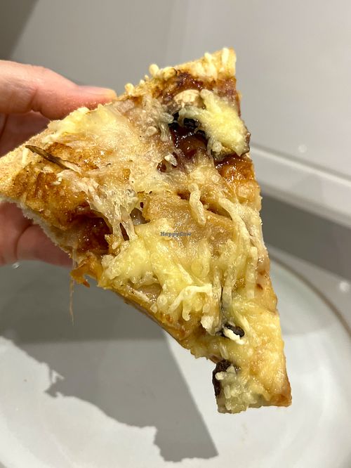 Slice of delivered Green BBQ vegan pizza with bbq sauce, plant based "meat", portobello mushrooms, fresh onion and grated vegan cheese at Papa John's  in Oviedo