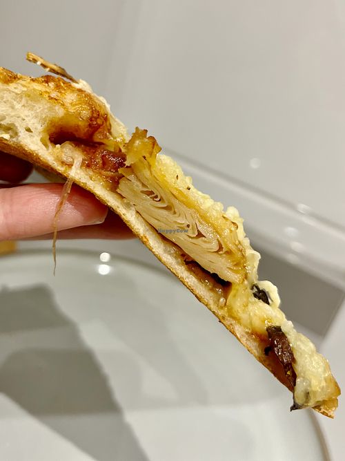 Slice of delivered Green BBQ vegan pizza with bbq sauce, plant based "meat", portobello mushrooms, fresh onion and grated vegan cheese at Papa John's  in Oviedo